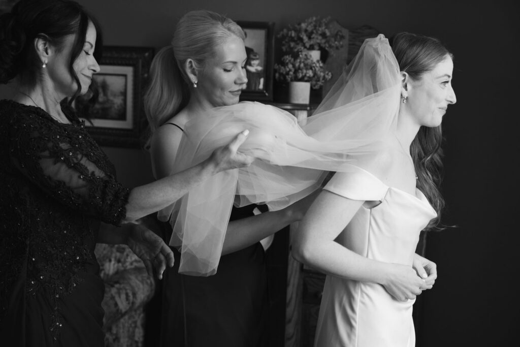 Bride getting into her wedding dress with help from family