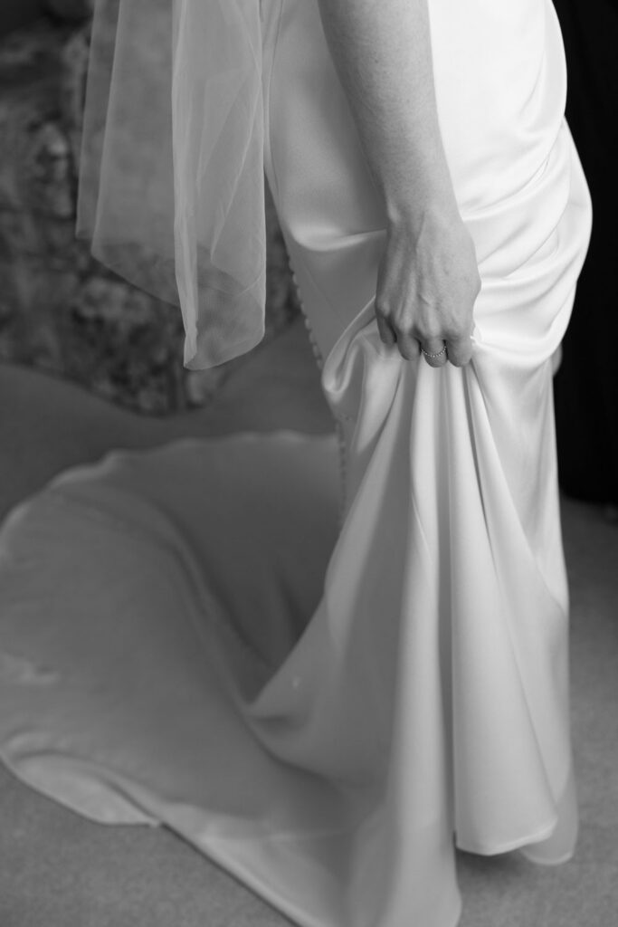 Bride adjusting wedding dress and veil during getting ready photos