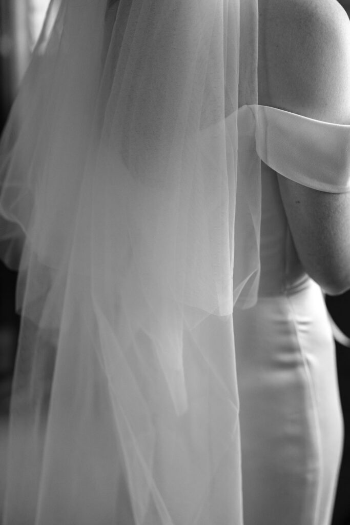 Bride adjusting wedding dress and veil during getting ready photos