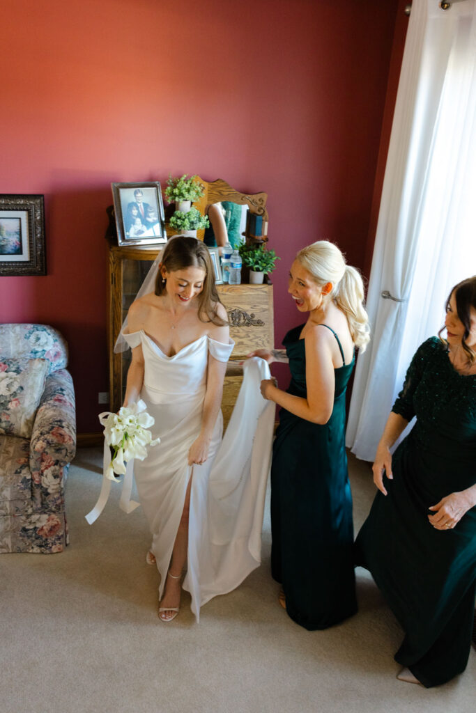 Bride getting into her wedding dress with help from family