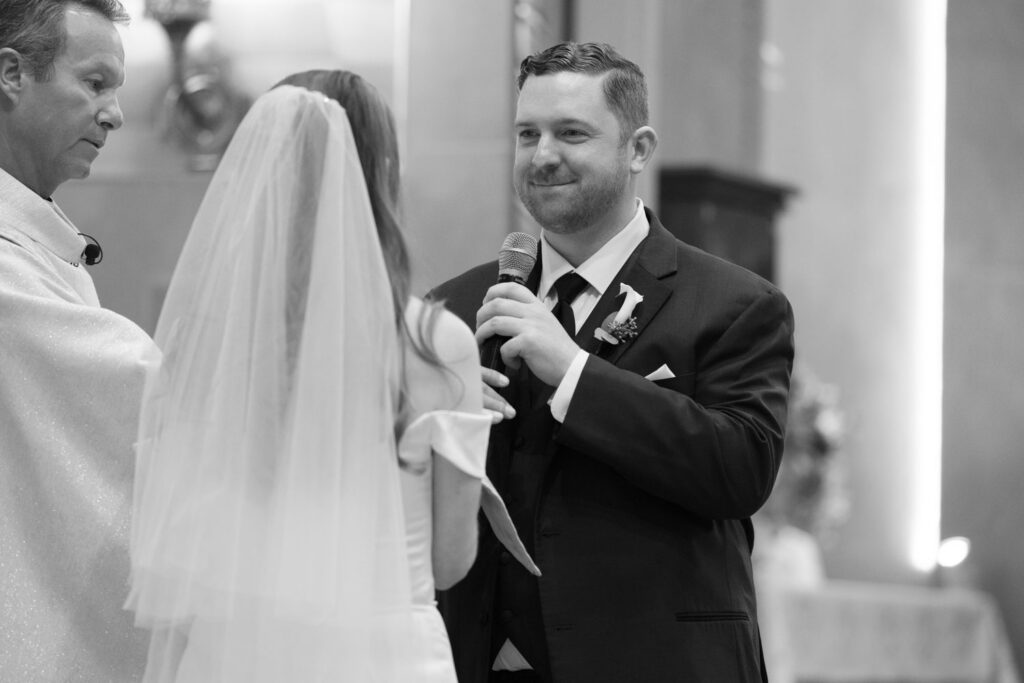 Bride and groom exchanging vows during Catholic wedding ceremony