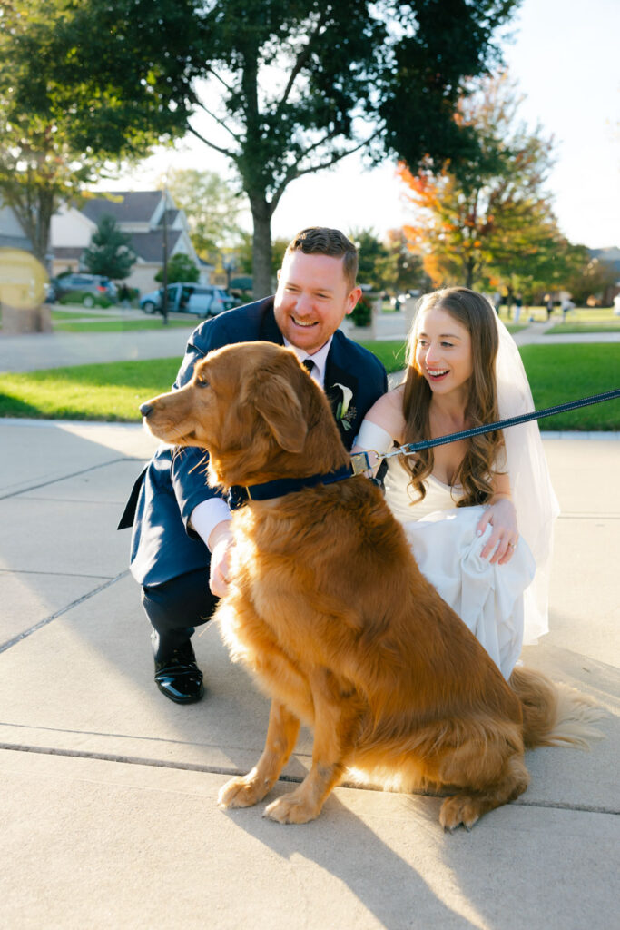 Bride and groom with golden retriever outside church after wedding ceremony