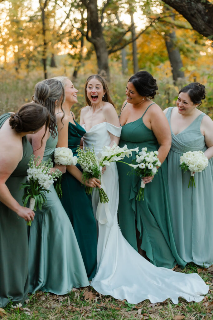 Bridesmaids in sage green dresses during fall wedding portraits