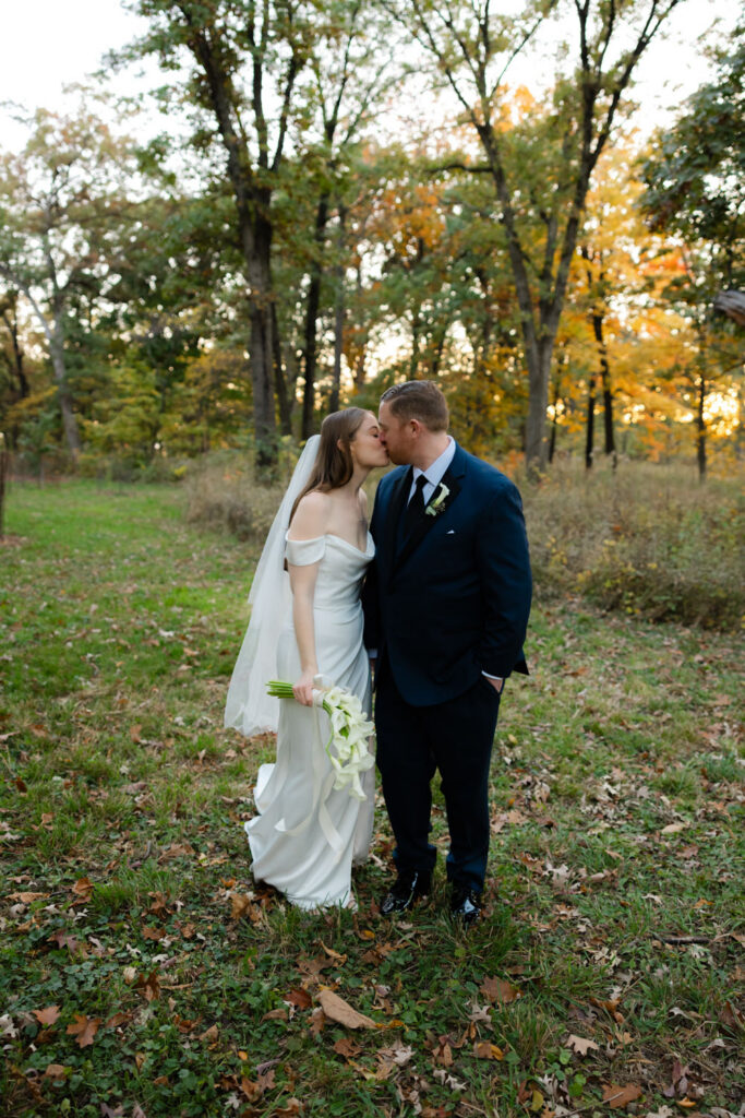 Bride and groom walking through wooded path at Morton Arboretum