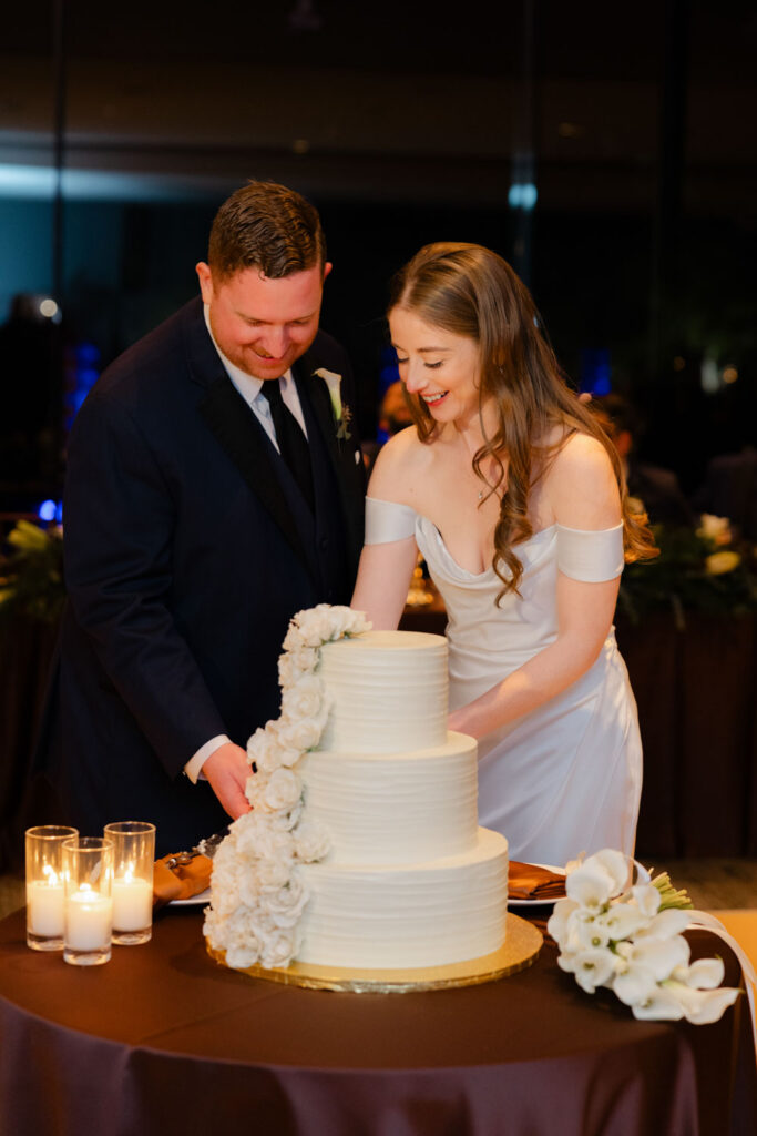 Bride and groom cutting wedding cake during reception