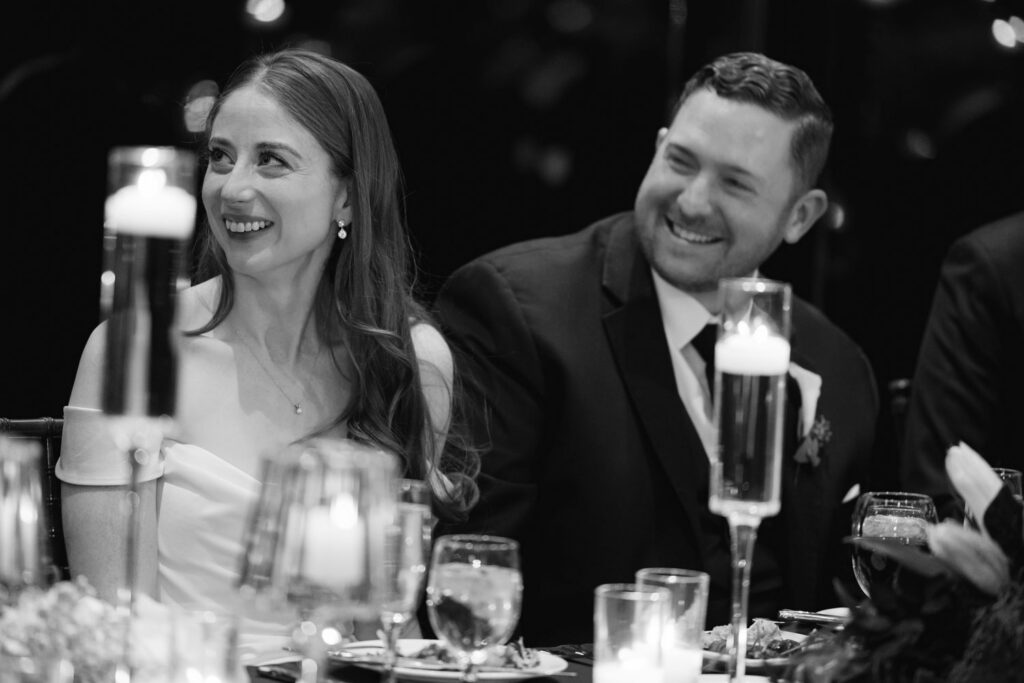 Bride and groom smiling during wedding toasts