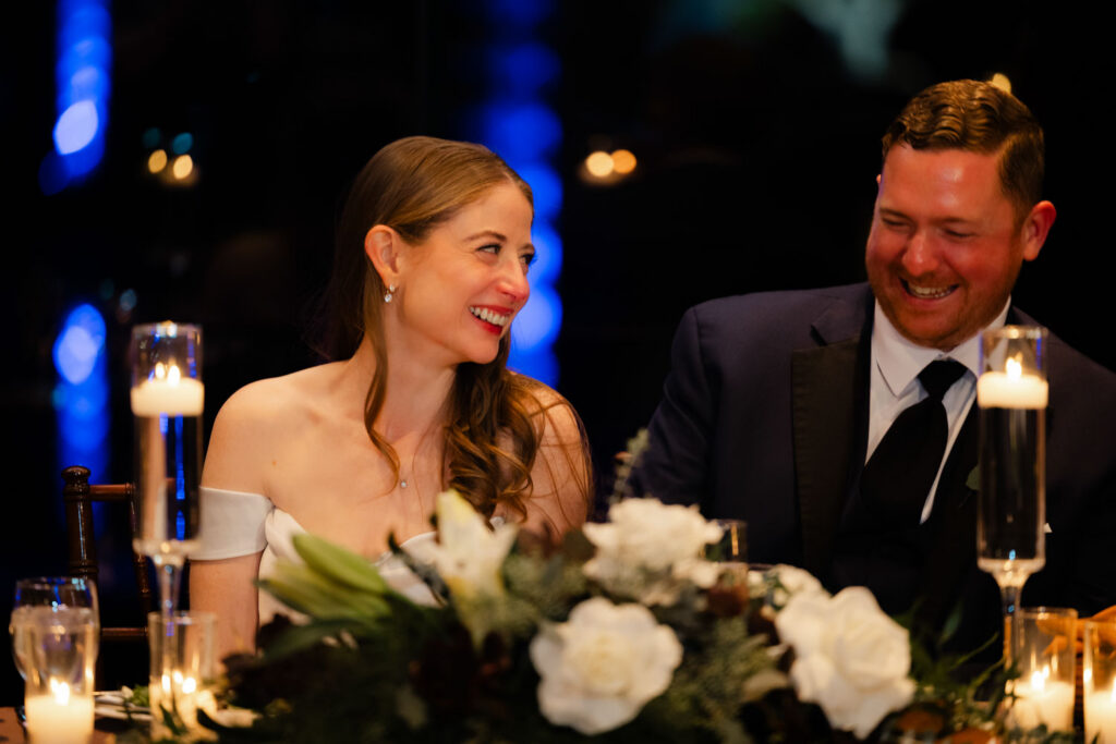 Bride and groom smiling during wedding toasts
