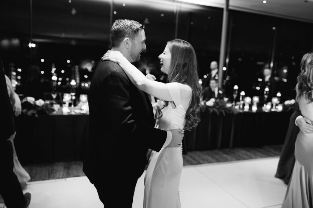 Bride and groom dancing together on packed dance floor
