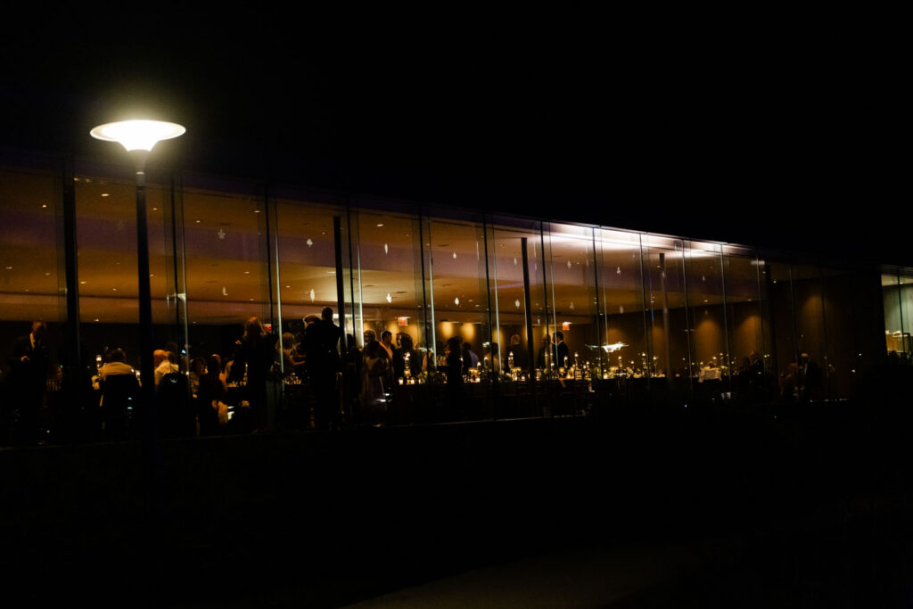 Night view of Morton Arboretum reception building glowing with candlelight
