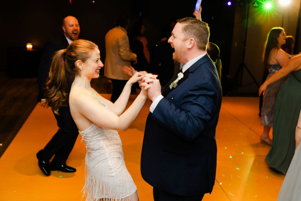Bride and groom dancing together on packed dance floor