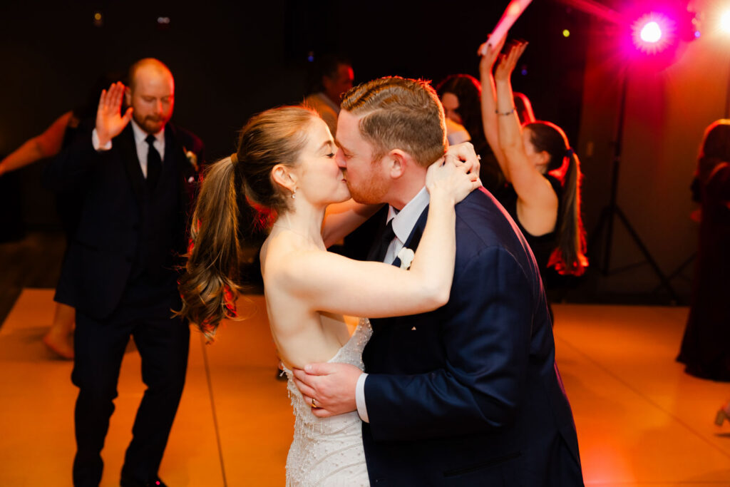Bride and groom dancing together on packed dance floor
