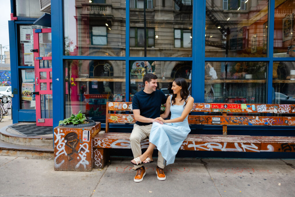 Couple sitting together outside colorful café window in Pilsen Chicago