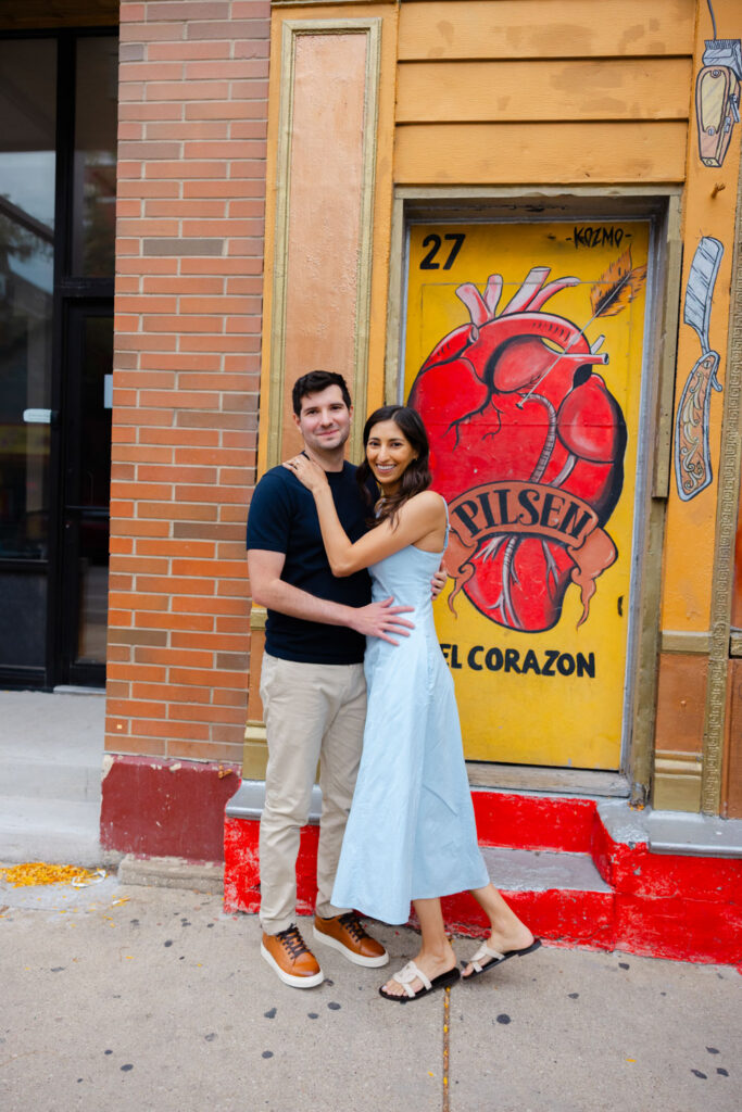 Couple embracing in front of El Corazon mural in Pilsen Chicago