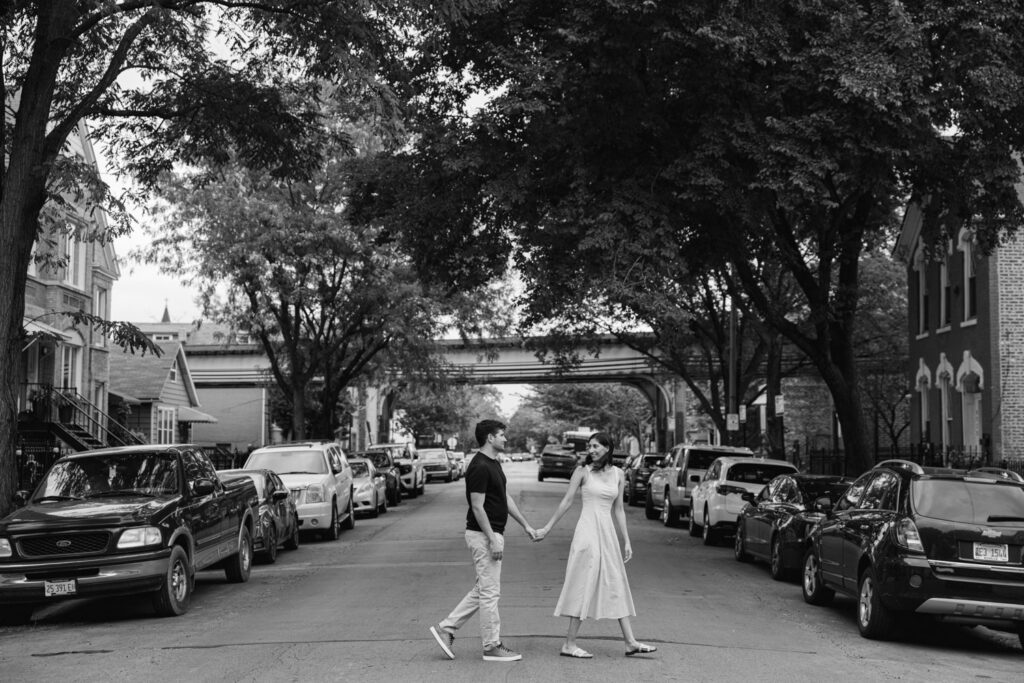Couple walking hand in hand down tree-lined Chicago neighborhood street