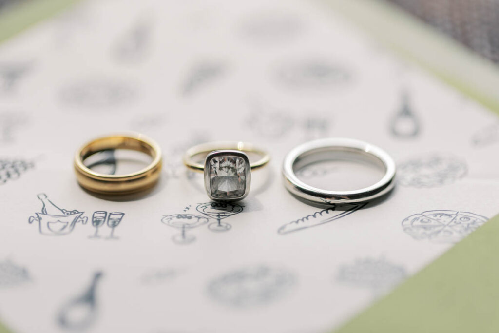 Engagement ring and wedding bands styled on invitation paper before a Chicago RPM Events wedding.