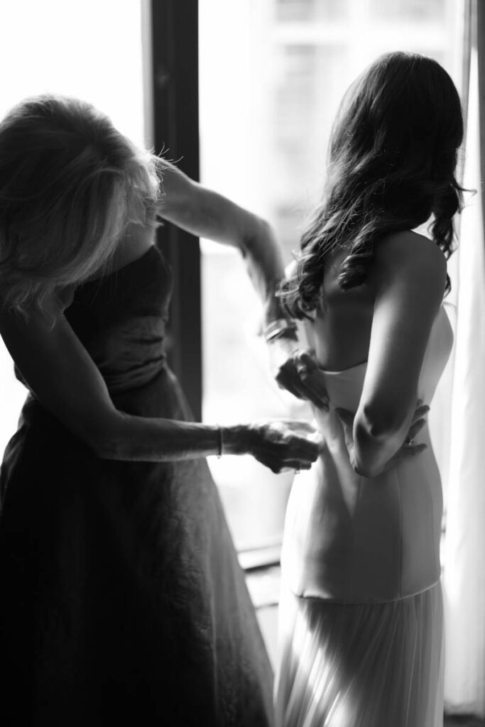 Bride getting dressed in soft window light before her RPM Events wedding in Chicago.