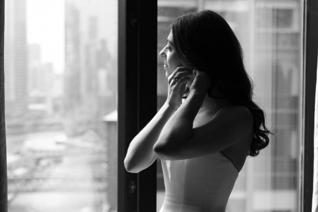 Bride getting dressed in soft window light before her RPM Events wedding in Chicago.