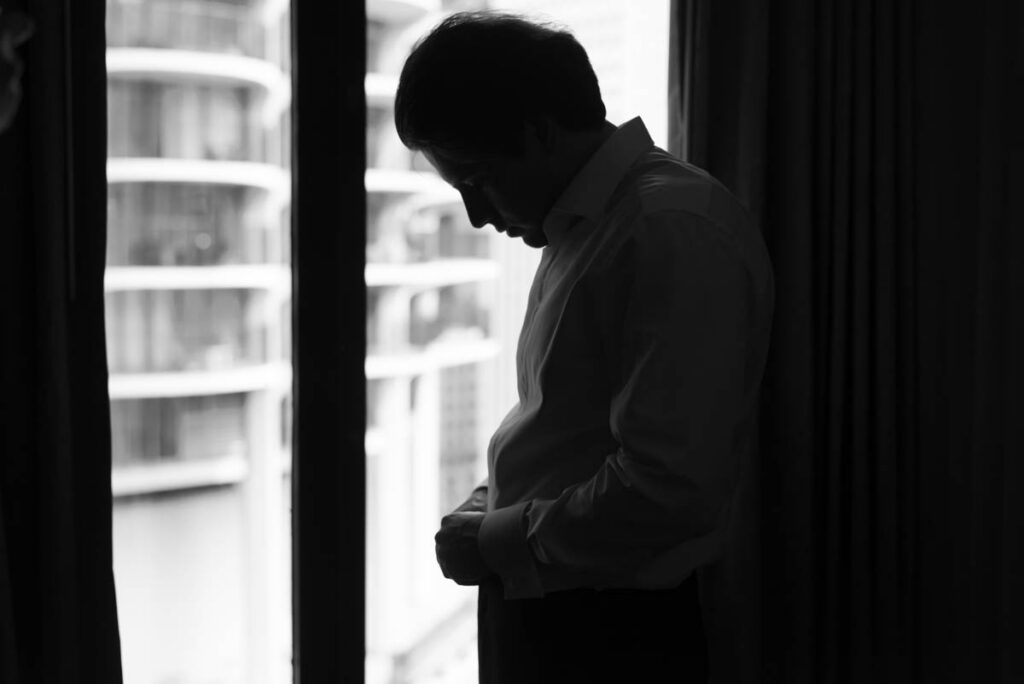 Groom fastening cufflinks in tuxedo prior to summer wedding at RPM Events Chicago.