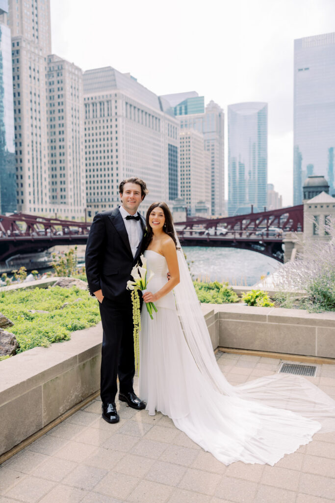 Bride and groom posing along the Chicago Riverwalk before their RPM Events wedding reception.