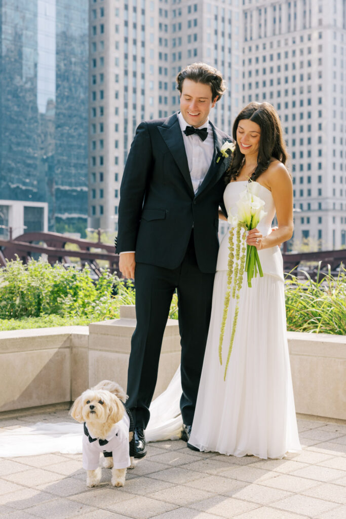 Couple embracing with downtown Chicago skyline in the background on their wedding day.