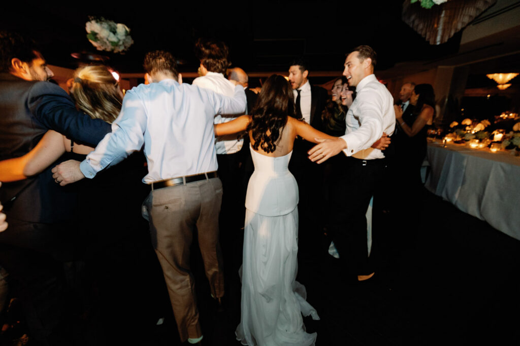 Guests dancing energetically during modern summer wedding reception in Chicago.