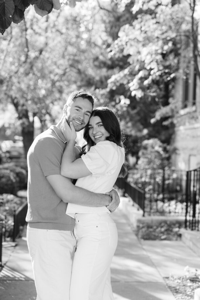 Couple embracing on quiet Chicago street in Lincoln Park black and white engagement photo