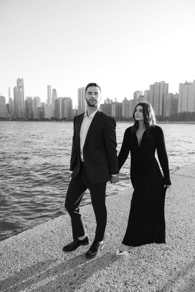 Couple walking along lakefront in Chicago during Lincoln Park engagement session black and white