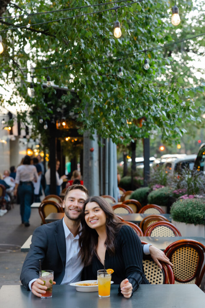 Couple enjoying drinks at outdoor patio restaurant in Lincoln Park Chicago engagement session
