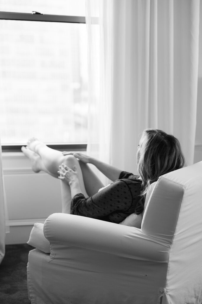 Woman reclining in chair by window in soft natural light