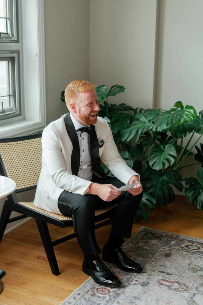 Groom sitting and reading a note before the first look.