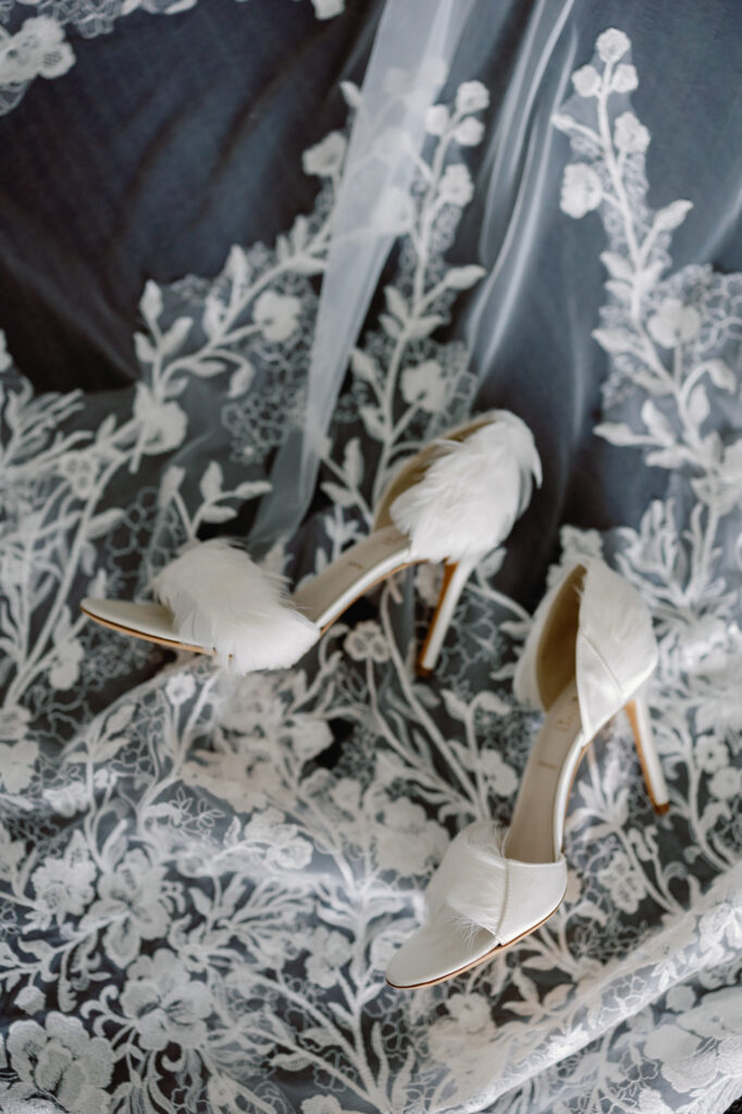 Close up of bridal accessories including shoes and floral details styled together.
