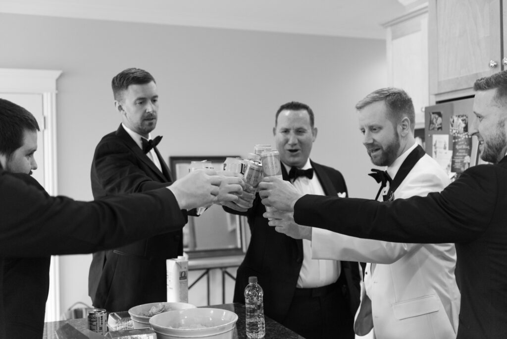 Groom celebrating with his groomsmen with a toast before the ceremony.