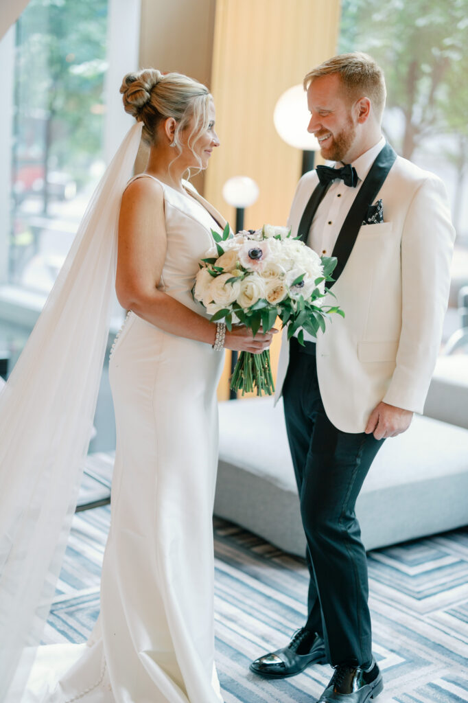Bride and groom seeing each other for the first time and smiling during their first look.