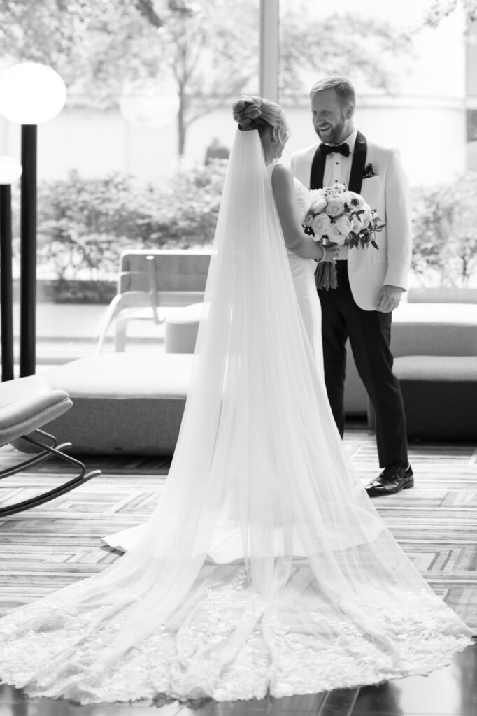 Groom looking at the bride as she walks toward him for their first look.