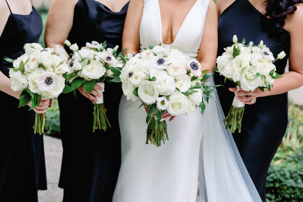 Close up of bridal bouquet with bridesmaids in black dresses during Chicago wedding portraits.