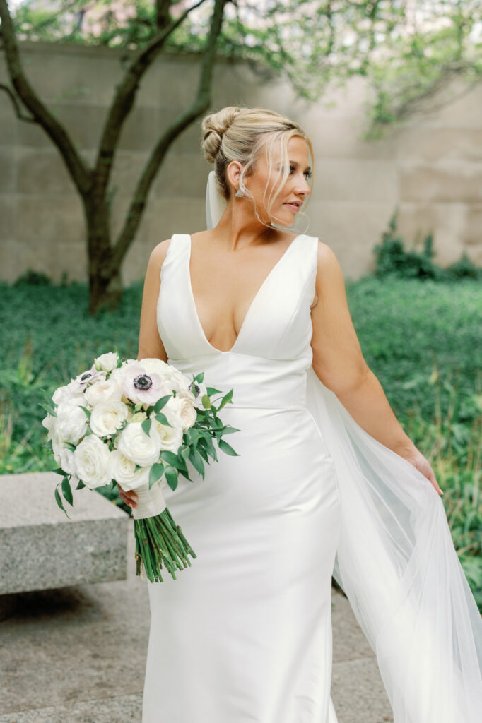 Bride looking over her shoulder holding her bouquet during Art Institute Gardens wedding portraits.