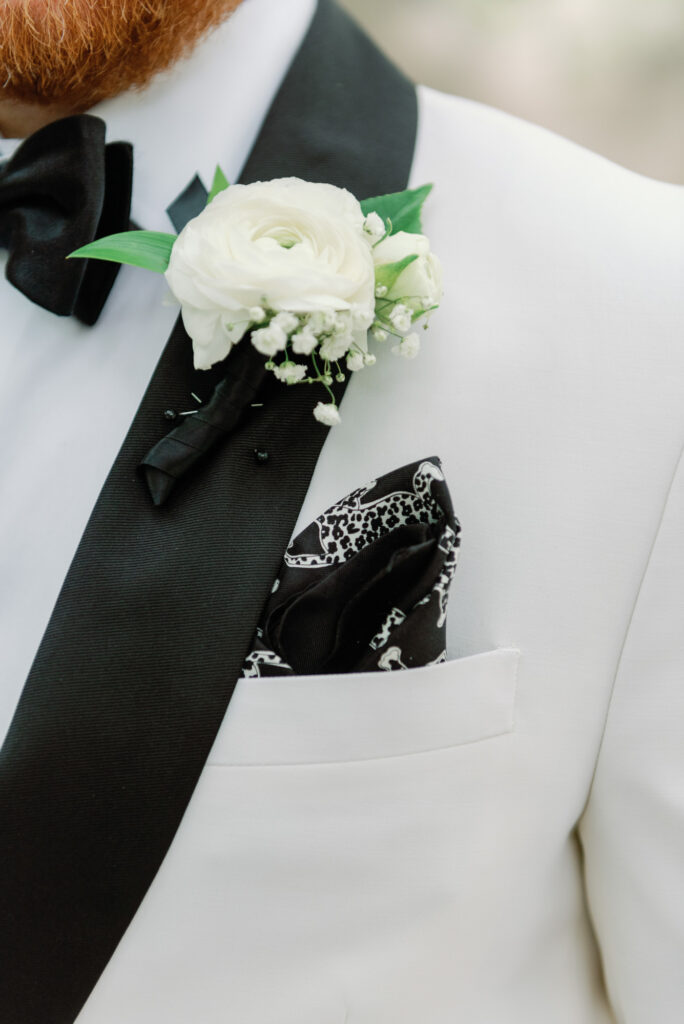 Groom’s boutonnière and tuxedo details photographed up close.