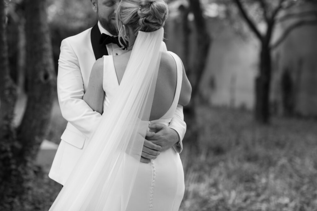 Bride and groom embracing during a quiet moment before heading to portraits.