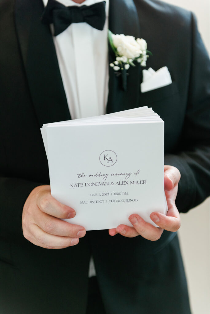 Groomsman holding a wedding program before the ceremony begins.
