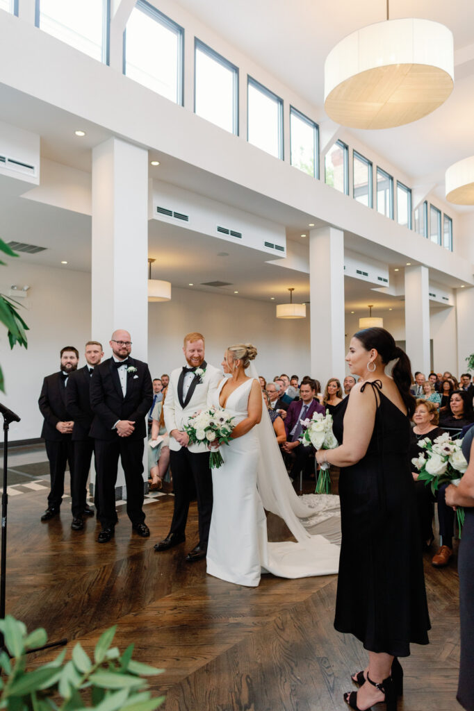 Bride and groom standing together during their ceremony at Mae District wedding in Chicago.