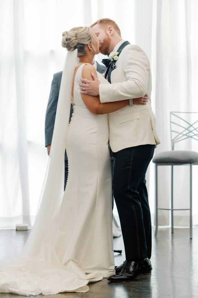 Bride and groom sharing their first kiss during their ceremony at Mae District in Chicago.