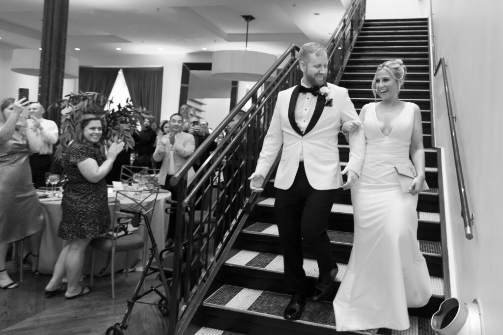 Bride and groom entering their reception space together at Mae District in Chicago.