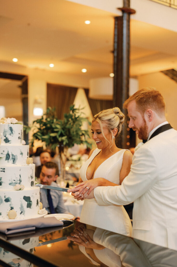 Bride and groom cutting their cake together during their Chicago wedding reception.