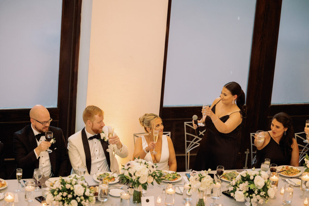 Bride and groom laughing together during dinner at their Mae District wedding.