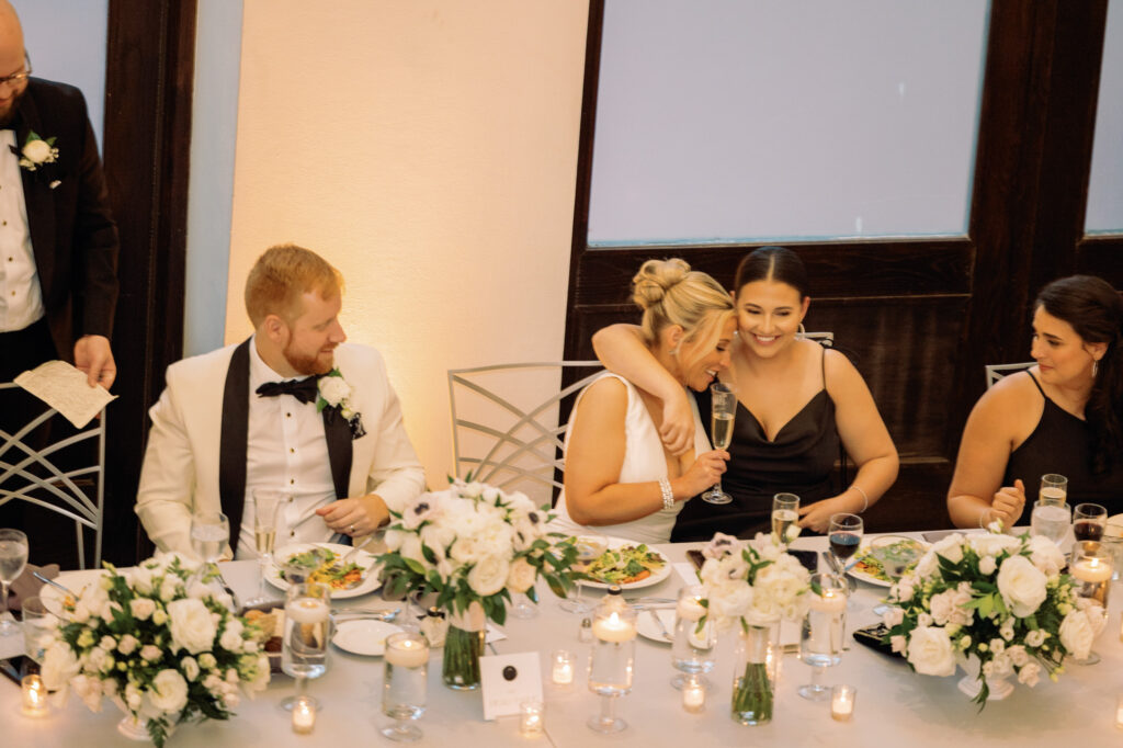 Bride and groom laughing together during dinner at their Mae District wedding.