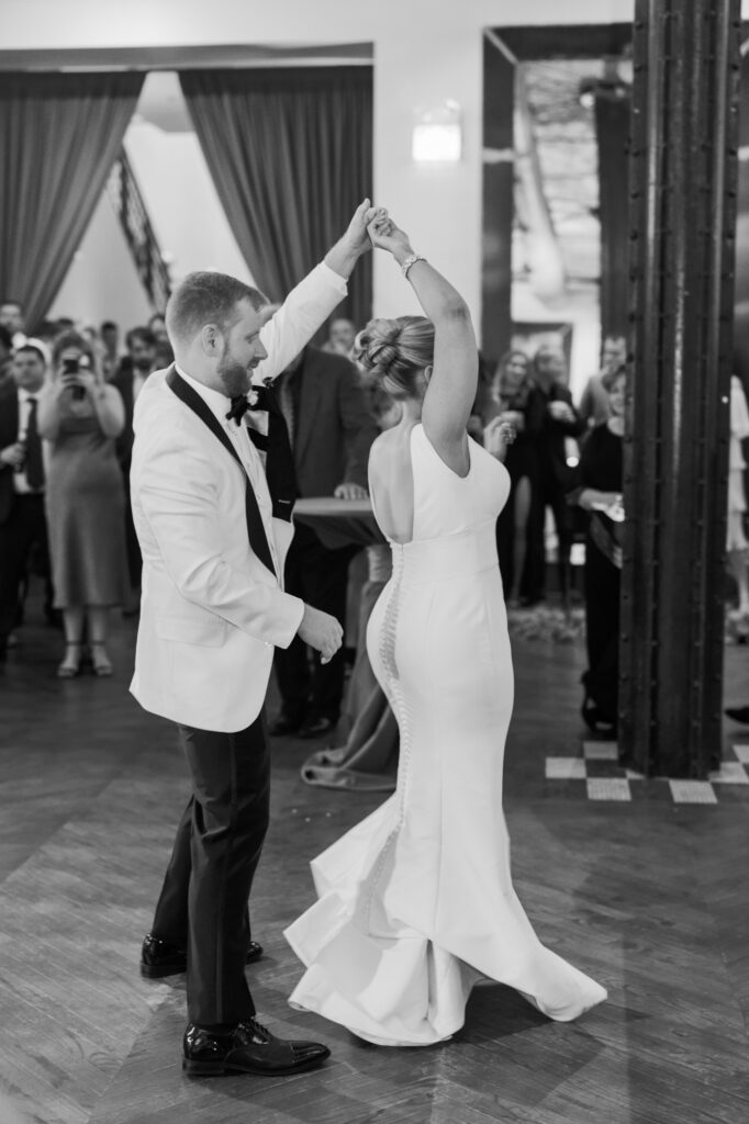 Bride and groom spinning and laughing during their first dance at Mae District.