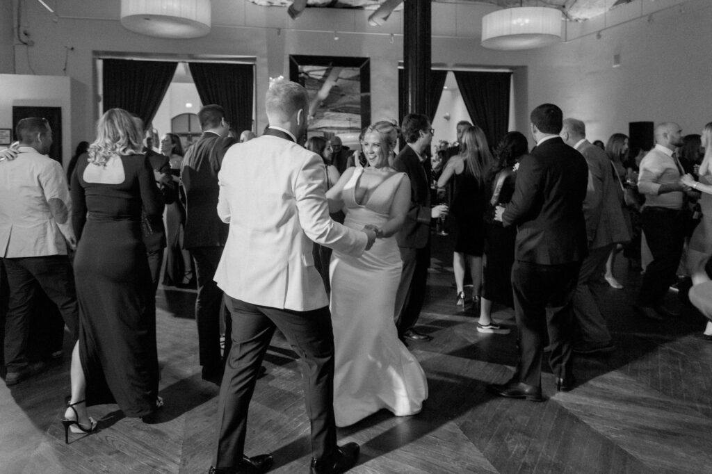 Guests dancing and celebrating on a packed dance floor at Mae District wedding in Chicago.