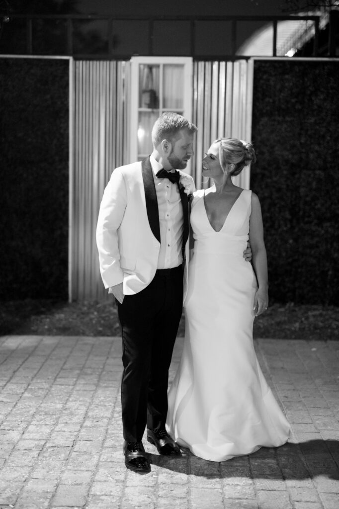 Bride and groom sharing a quiet moment together outside at night after their wedding.