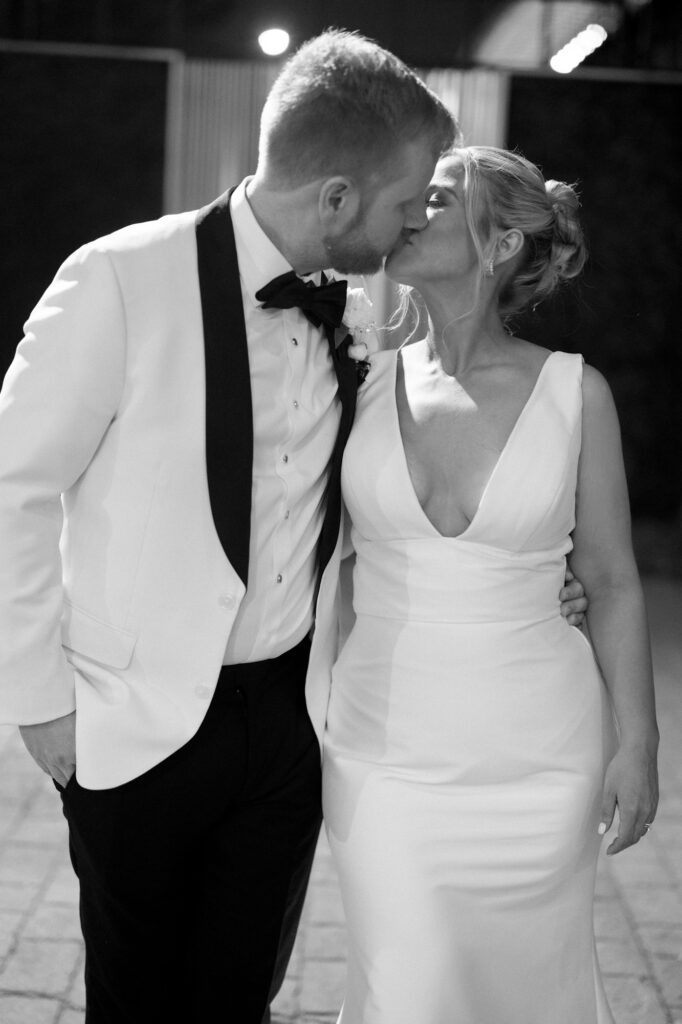 Bride and groom walking together at night holding hands after their reception.