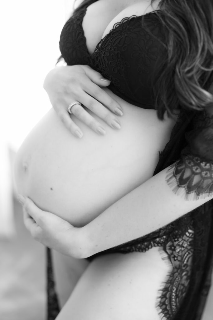 Close up of pregnant belly in black lingerie during Chicago maternity boudoir session